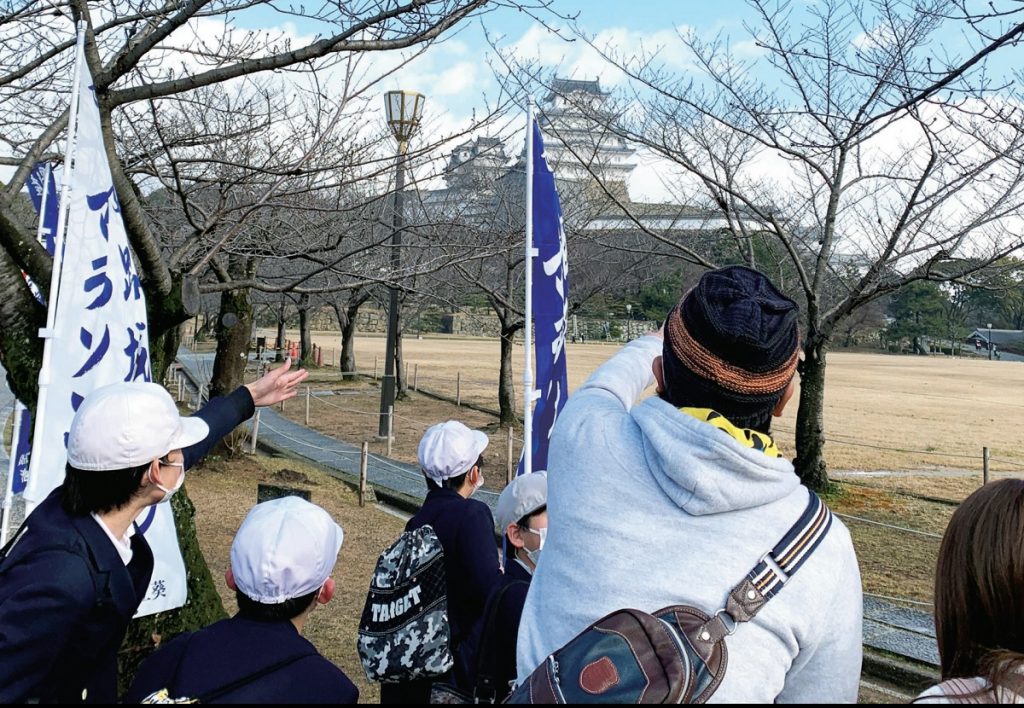 ガイドさんといっしょに姫路城をガイドする子供たちの写真