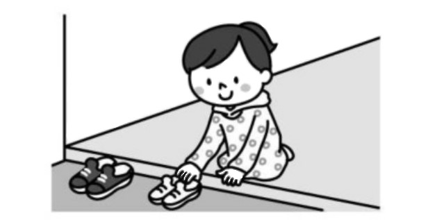 玄関で靴を揃える子供
