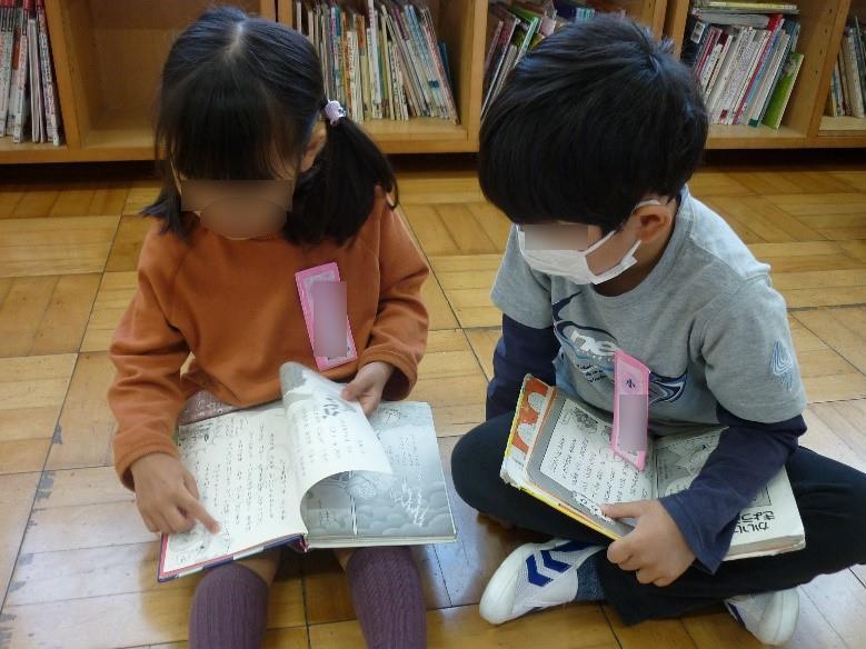 絵本を読みながら、友達と交流する子供たち。