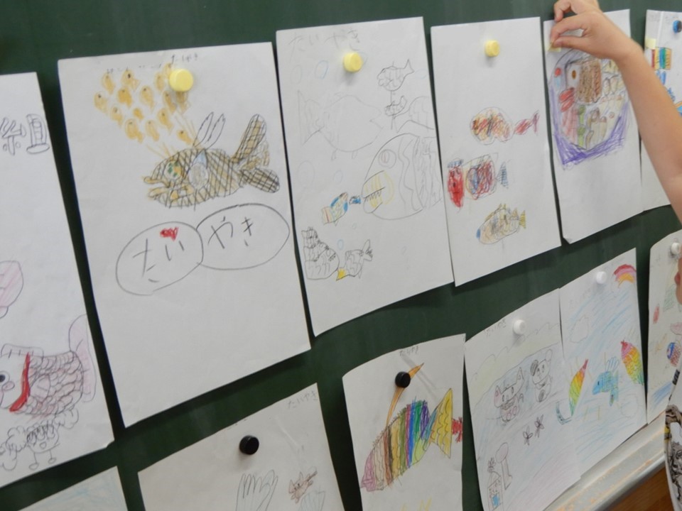 ３Ｄ学級目標のデザインコンテストのために、子供が描いたイラスト。一人一人の作品を黒板に貼り、投票を開始する。