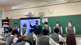 黒板の前でスピーチする生徒たちの写真