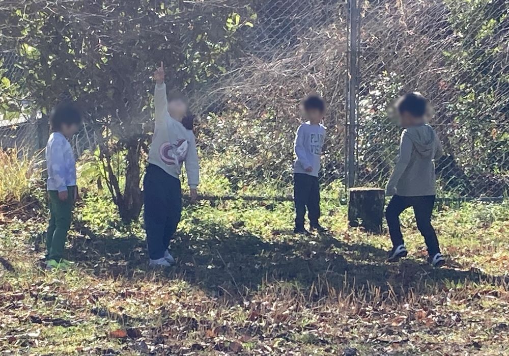 校庭で冬みつけをする子供。