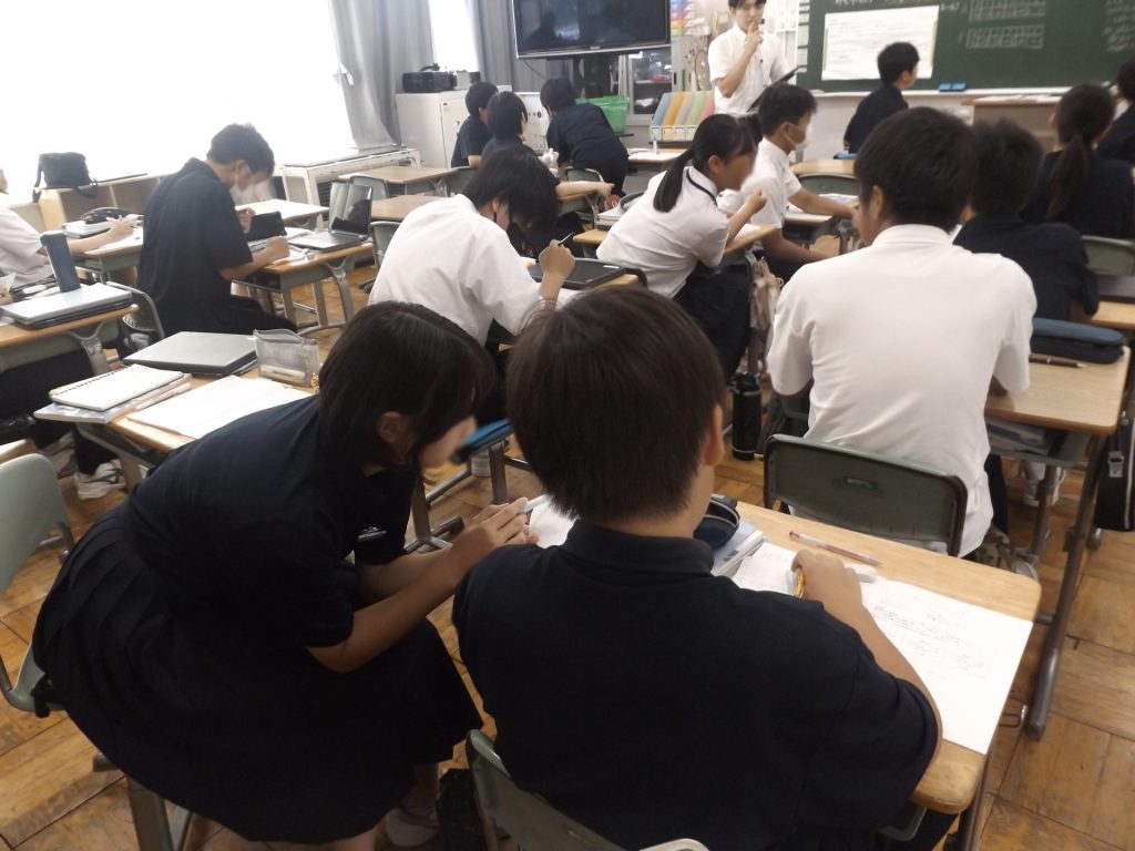 隣同士で意見交換しながら問題解決に取り組む子供たちと様子を見取る鷹野教諭。