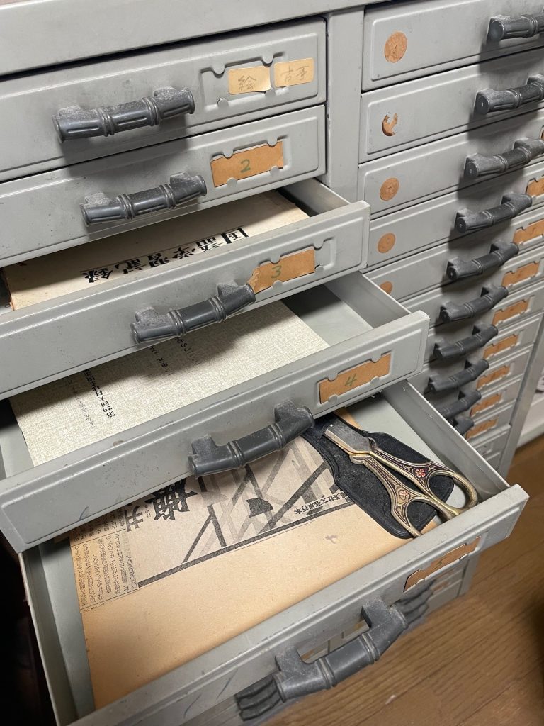 大村がことばの材料や教材を集めるために大事にしたスチールのキャビネット。１台に40個の引き出しがある。これを２台、計80の引き出しを持っていたが、あっという間に集めた材料ははみだし、部屋は資料を収めた茶封筒だらけとなった。このキャビネットは筆者に譲られ、筆者の自宅に置かれている。