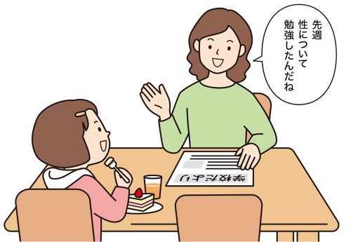 学校だよりを見ながら会話する母親と子供。「先週、性について勉強したんだね」と母親。