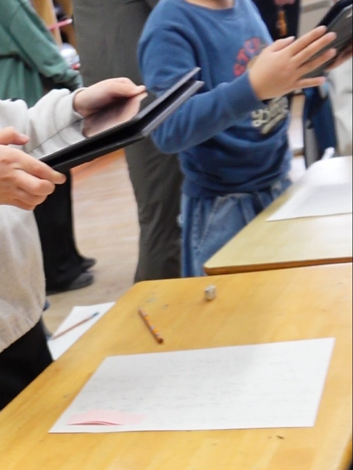 書いた詩を端末で撮影する子供たち