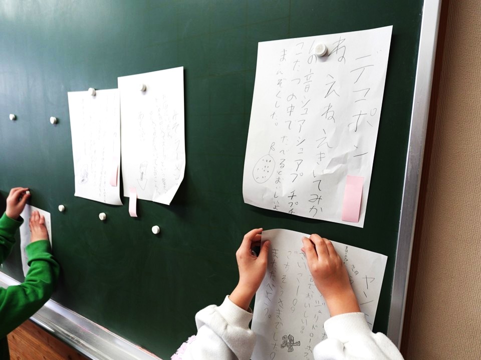 黒板に詩を貼り出そうとしている授業中の様子
