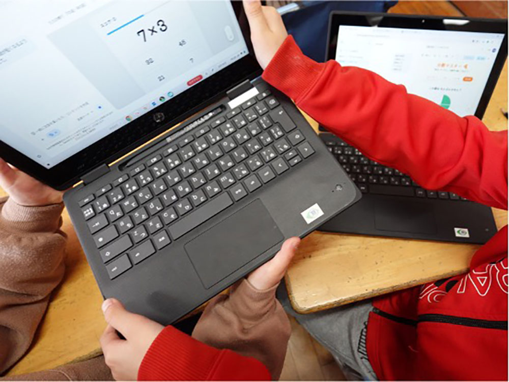 端末を隣の子と交換している写真