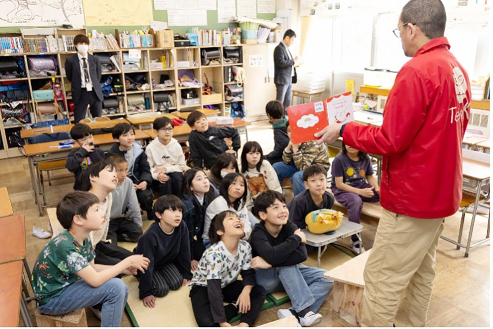 絵本を読み聞かせる大窪教諭と、中央のスペースで聞く子どもたち。