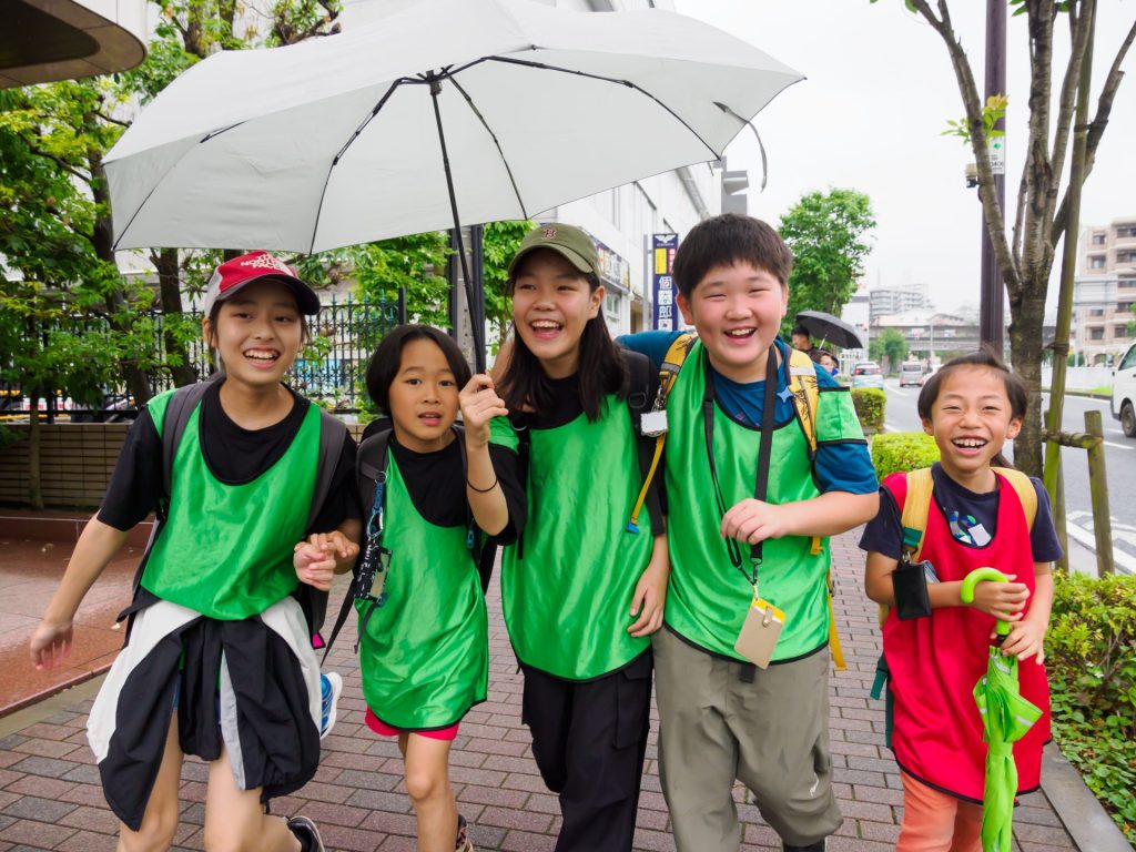 雨の日の子どもたち。カメラを向けられても笑顔でいっぱい。