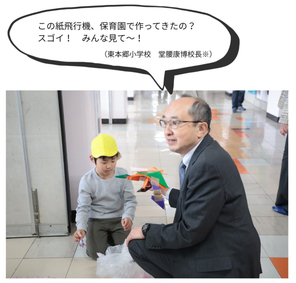 堂腰校長　吹き出し　）
この紙飛行機、保育園で作ってきたの？　スゴイ！　みんな見て～！（東本郷小学校　堂腰康博校長※）
