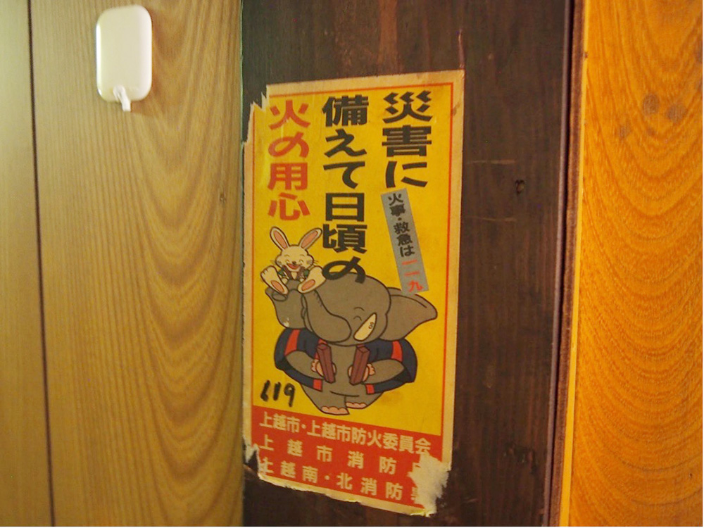 「たてよこ書店」の柱に残された火の用心を呼びかけるステッカー